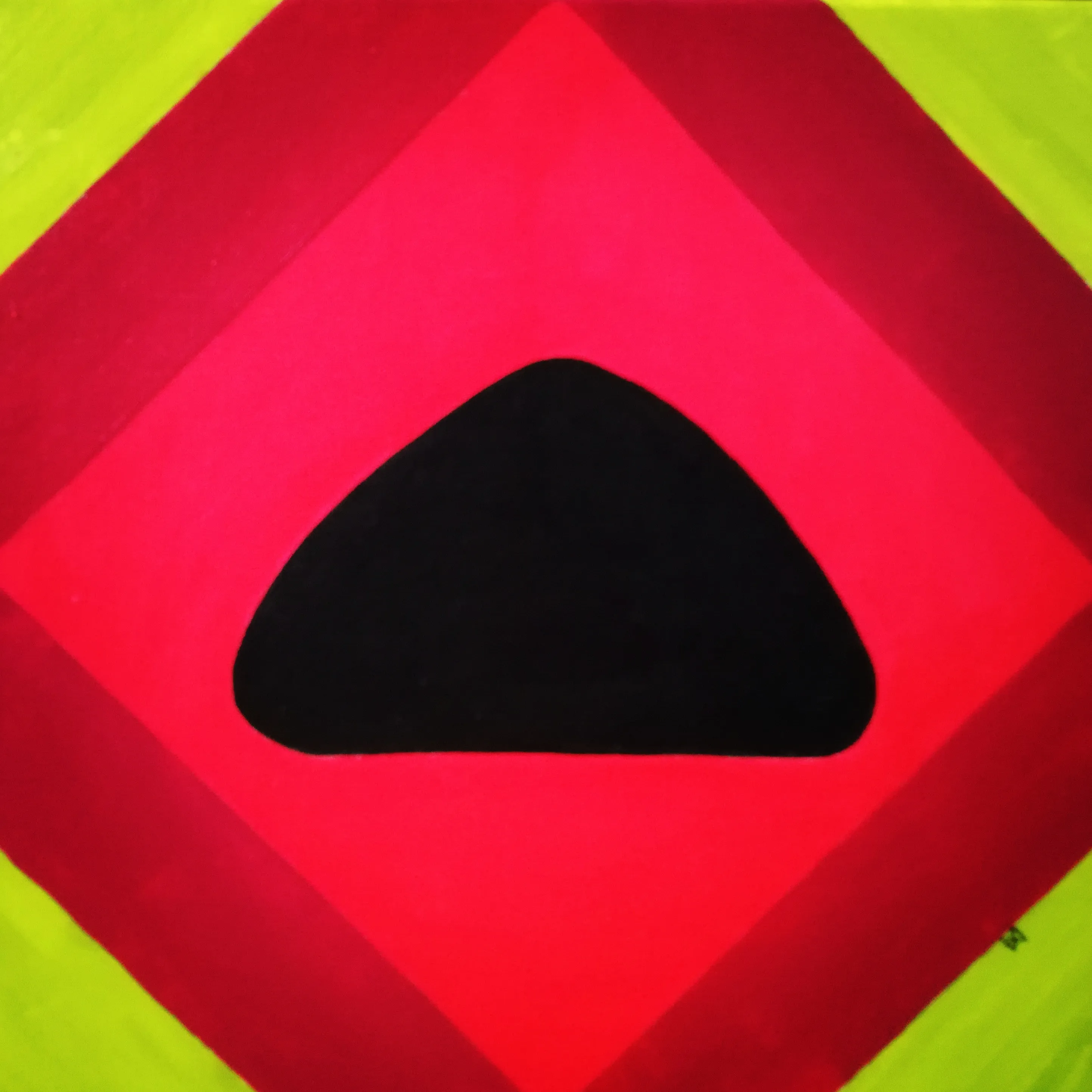 Painting of a black triangular stone at the centre of nested red and pink diamonds on a lime green ground.